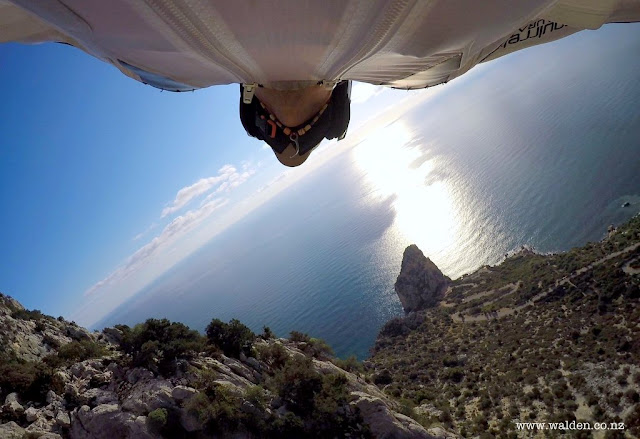 David jumping from Punta Su Malone with a view of Pedra Longa.